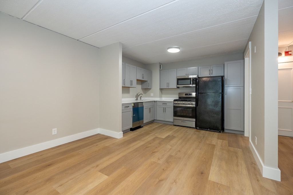 1500 Worcester Road, Unit 217 Framingham, MA 01702 - Photo 14 of 37 a kitchen with stainless steel appliances a refrigerator and a stove top oven