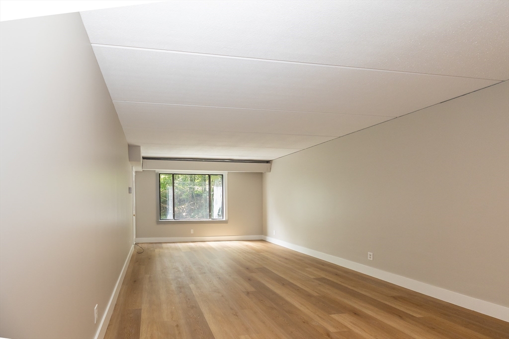 1500 Worcester Road, Unit 217 Framingham, MA 01702 - Photo 15 of 37 an empty room with wooden floor and windows