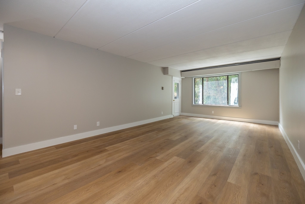 1500 Worcester Road, Unit 217 Framingham, MA 01702 - Photo 17 of 37 a view of empty room with wooden floor and fan