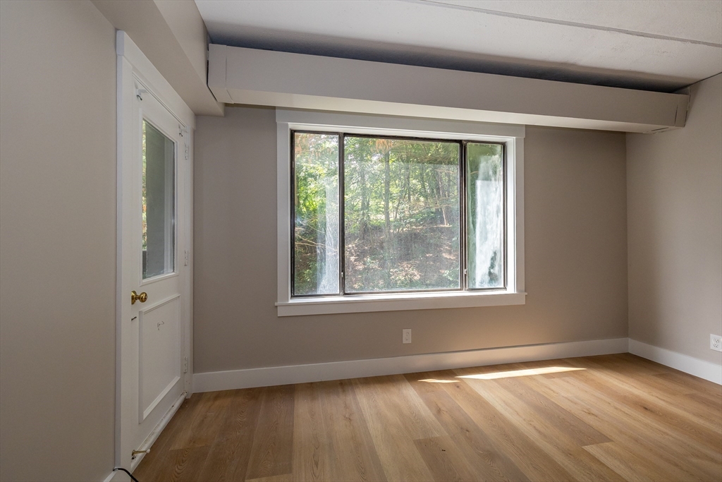 1500 Worcester Road, Unit 217 Framingham, MA 01702 - Photo 18 of 37 a view of an empty room with wooden floor and a window