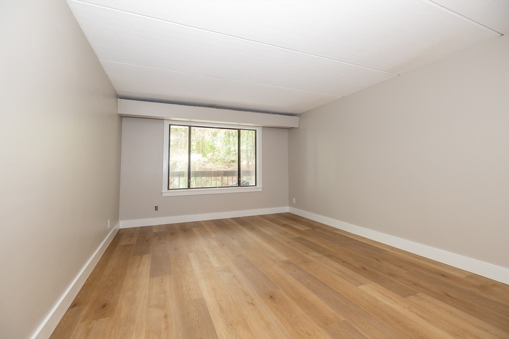 1500 Worcester Road, Unit 217 Framingham, MA 01702 - Photo 19 of 37 an empty room with wooden floor and windows