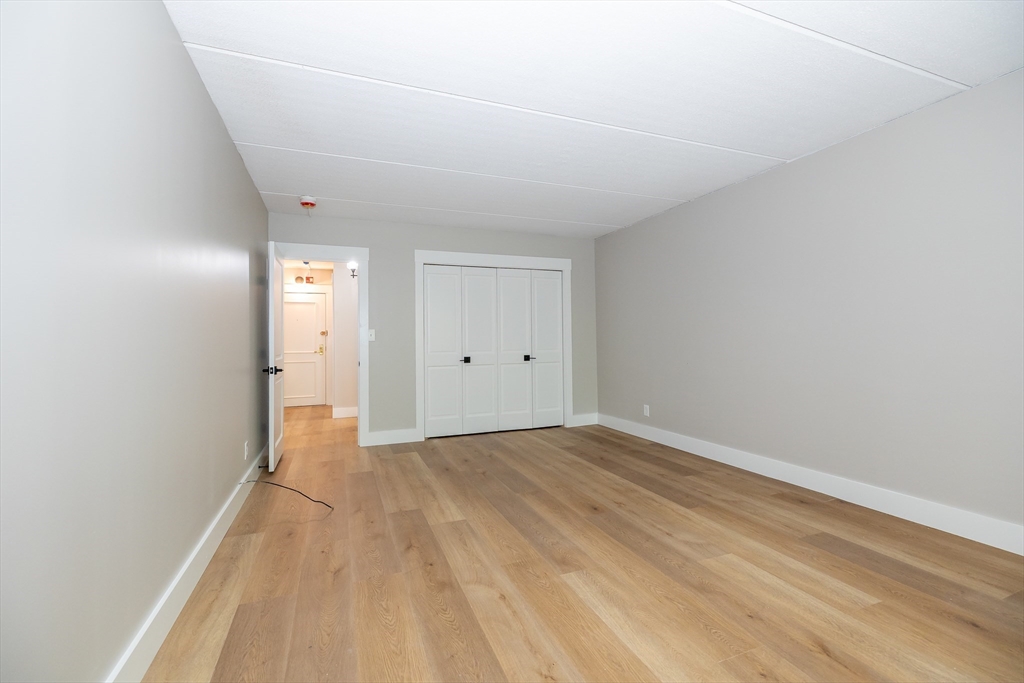 1500 Worcester Road, Unit 217 Framingham, MA 01702 - Photo 20 of 37 a view of an empty room with wooden floor