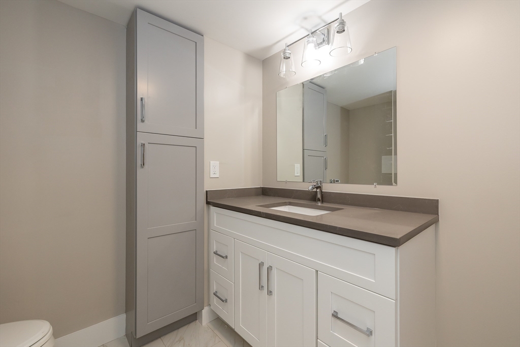 1500 Worcester Road, Unit 217 Framingham, MA 01702 - Photo 23 of 37 a bathroom with a granite countertop sink and a mirror