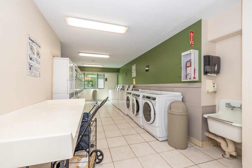 1500 Worcester Road, Unit 217 Framingham, MA 01702 - Photo 25 of 37 a room with a washing machine and a table chair