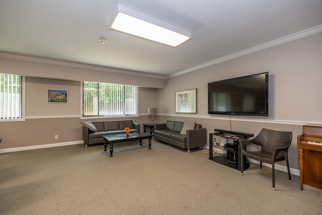 1500 Worcester Road, Unit 217 Framingham, MA 01702 - Photo 29 of 37 a living room with furniture and a flat screen tv
