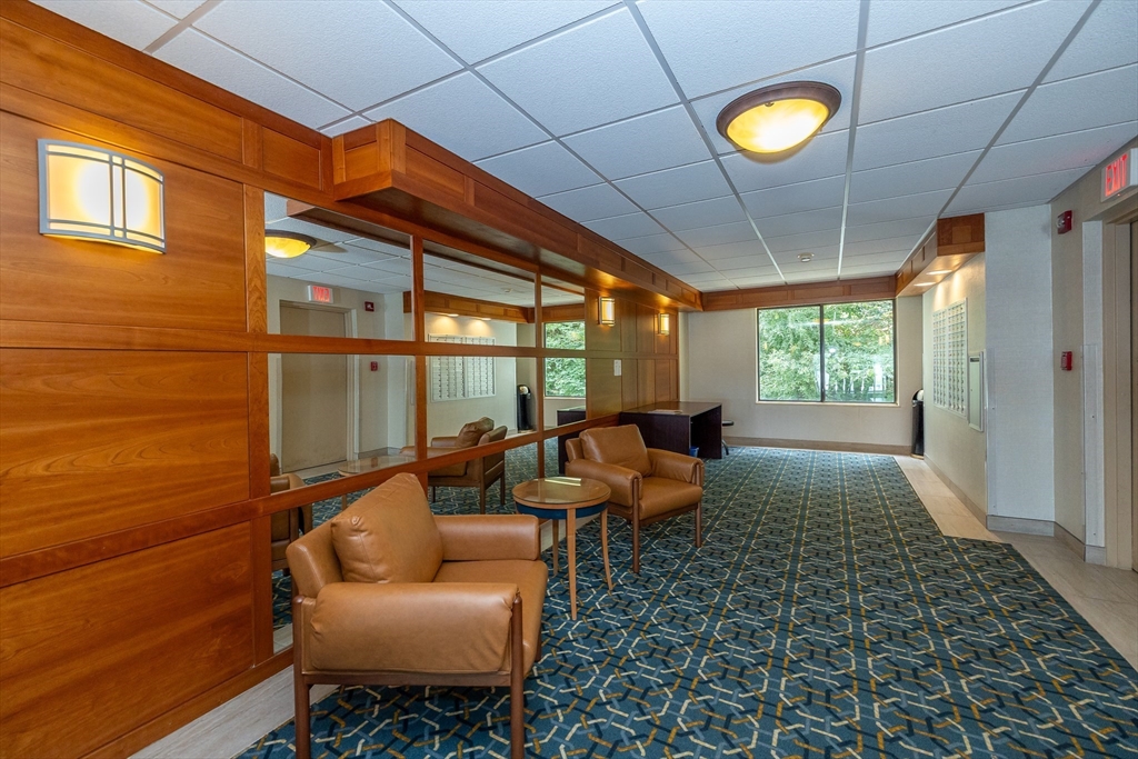1500 Worcester Road, Unit 217 Framingham, MA 01702 - Photo 8 of 37 a living room with furniture and a floor to ceiling window