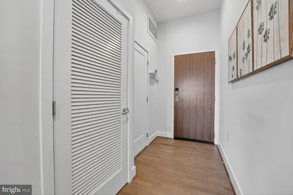 a view of a hallway with white wooden cabinets
