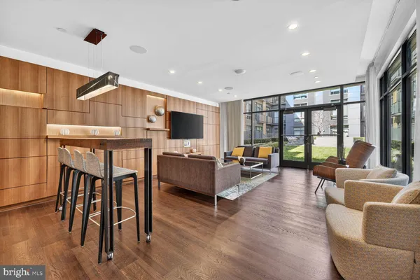 a living room with furniture a wooden floor and a flat screen tv