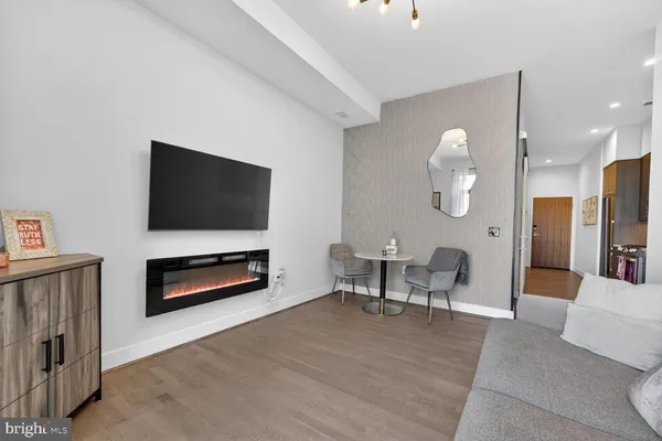 a living room with furniture a flat screen tv and kitchen view
