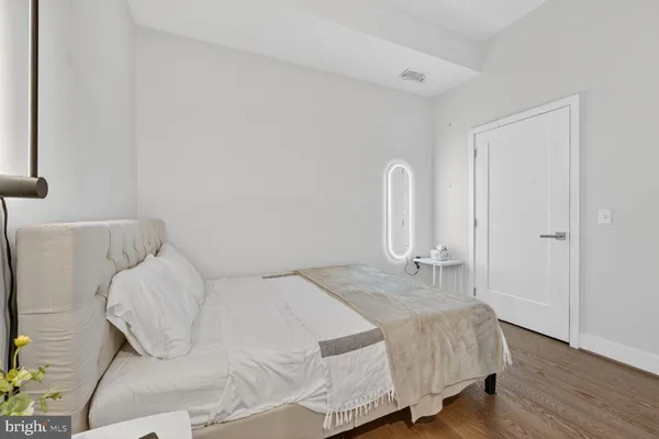 a bedroom with a bed and wooden floor