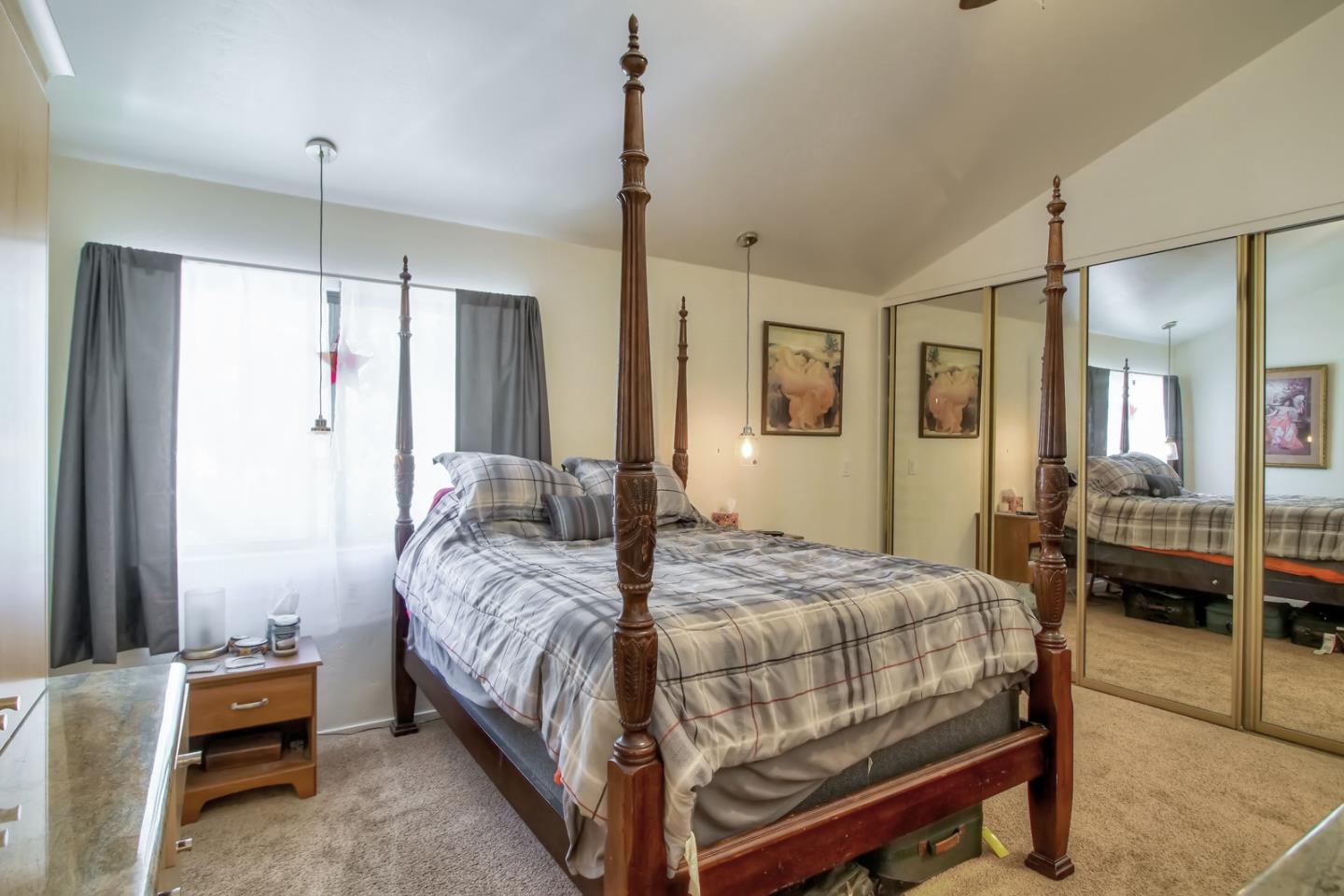709 Timber Trail Pacific Grove, CA 93950 - Photo 10 of 19 a bedroom with a bed a table and a chandelier