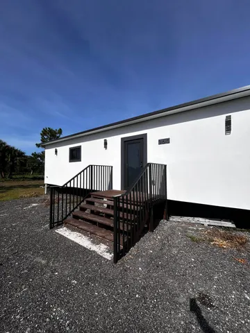 a backyard of a house with table and chairs