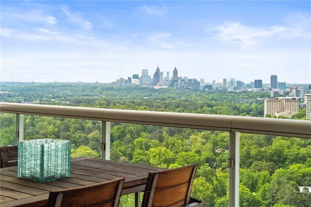 a living room with a balcony a couch and a table with wooden floor