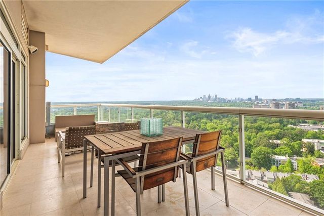 a view of a balcony with furniture and floor to ceiling window