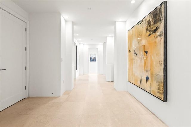 a room with stainless steel appliances kitchen island granite countertop a dining table chairs and a refrigerator