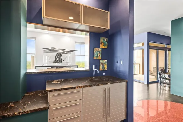 a bathroom with a granite countertop sink a toilet and mirror