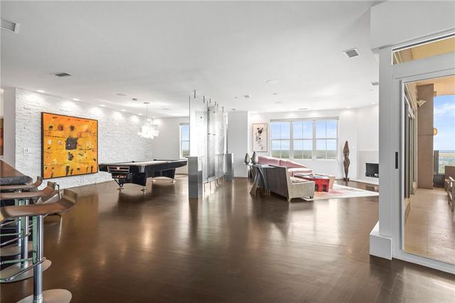 a living room with stainless steel appliances granite countertop furniture rug and wooden floor