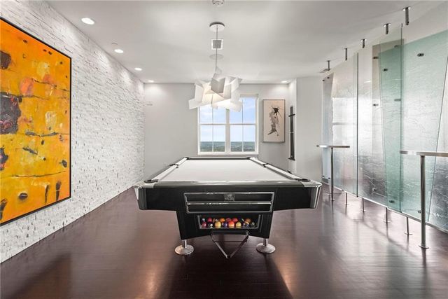 a kitchen with stainless steel appliances kitchen island granite countertop a refrigerator a stove and a sink with wooden floor