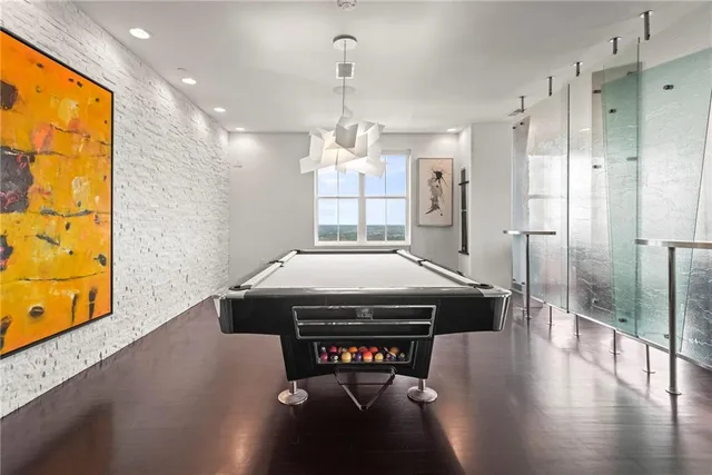 a kitchen with stainless steel appliances kitchen island granite countertop a refrigerator a stove and a sink with wooden floor