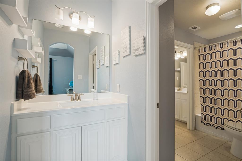 388 Bethany Road Sunnyvale, TX 75182 - Photo 31 of 40 Bathroom featuring a white vanity with integrated sink, a wall-mounted mirror, and a three-light fixture