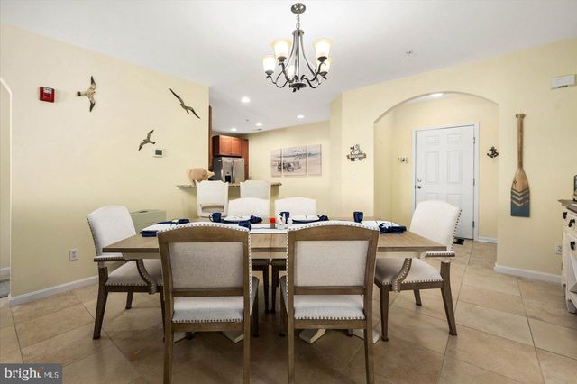 a large kitchen with granite countertop a sink refrigerator and cabinets