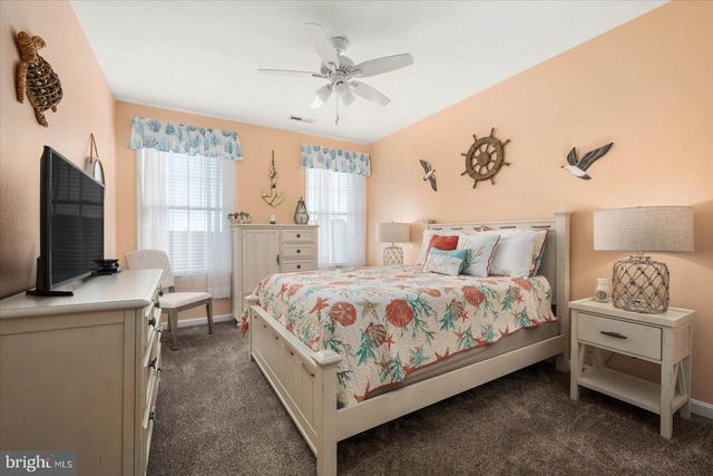 a front view of a house with glass windows and plants