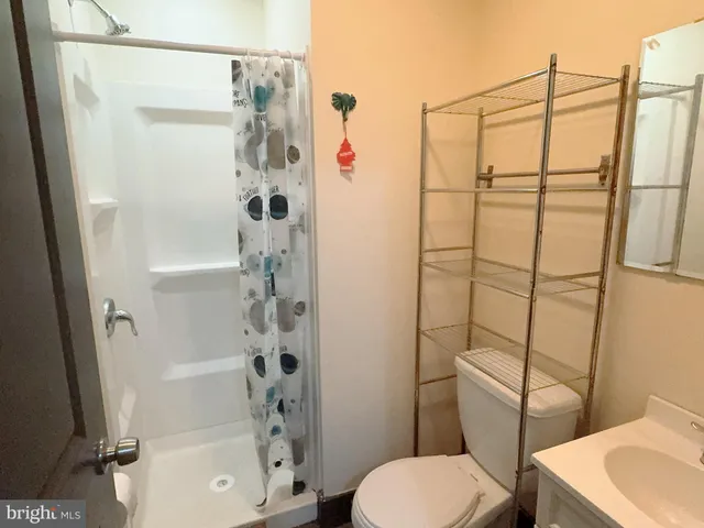 a bathroom with a shower a toilet and a sink