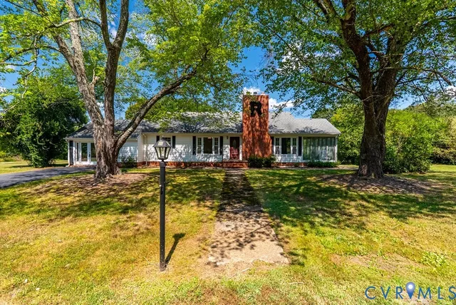 a house view with swimming pool and trees in the background