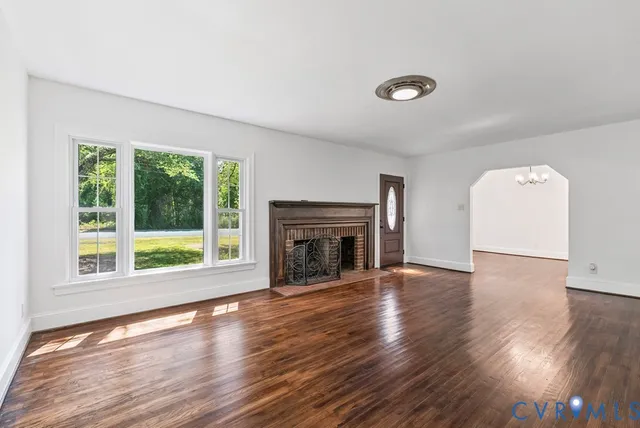 a view of an empty room with window and fireplace