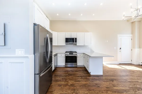 a kitchen with stainless steel appliances granite countertop a stove a refrigerator and a microwave