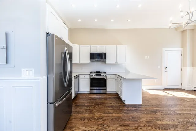 a kitchen with stainless steel appliances granite countertop a stove a refrigerator and a microwave