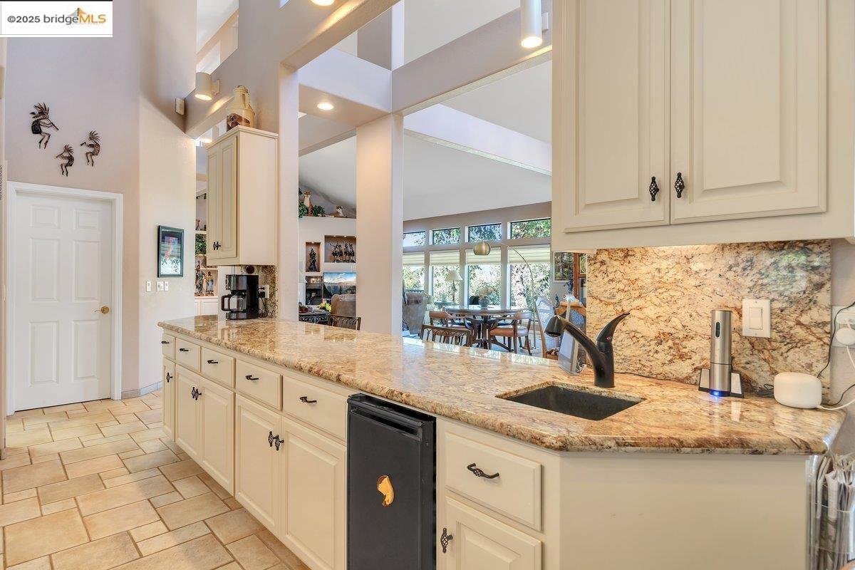 13700 Clements Road Groveland, CA 95321 - Photo 21 of 93 Kitchen featuring light stone countertops, tasteful backsplash, cream cabinetry, recessed lighting, and lofted ceiling