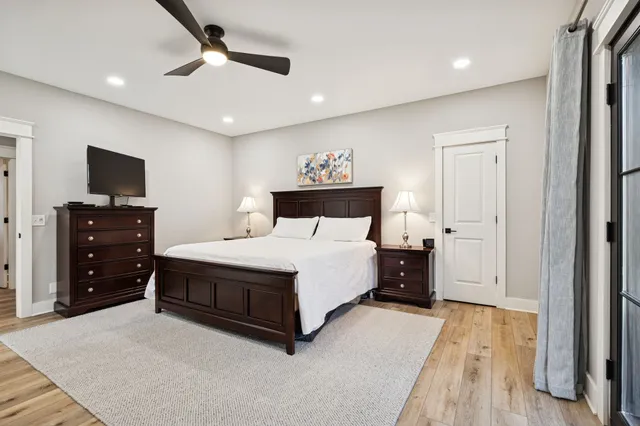 a spacious bedroom with a bed and a flat screen tv