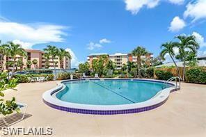 200 Pebble Beach Boulevard, Unit D402 Naples, FL 34113 - Photo 2 of 11 a view of swimming pool with outdoor seating and plants
