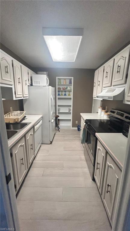 200 Pebble Beach Boulevard, Unit D402 Naples, FL 34113 - Photo 3 of 11 a kitchen with stainless steel appliances a white cabinets and a stove top oven