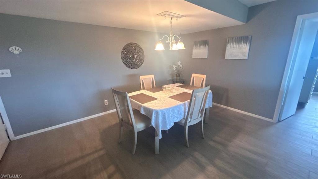 200 Pebble Beach Boulevard, Unit D402 Naples, FL 34113 - Photo 5 of 11 a view of a dining room with furniture and wooden floor