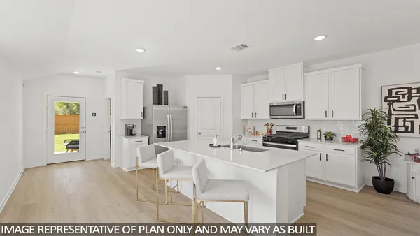 a kitchen that has a sink and a stove top oven