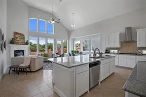 a kitchen with kitchen island granite countertop a stove and a view of living room