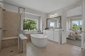 a spacious bathroom with a bathtub sink and mirror