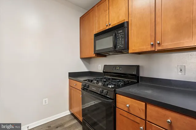 a view of a kitchen with wooden floor and a refrigerator