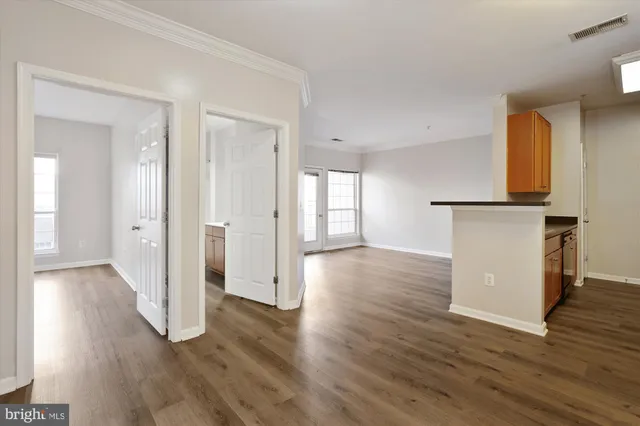 a view of a room with wooden floor and a window