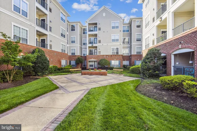 a view of a building with garden and tall trees