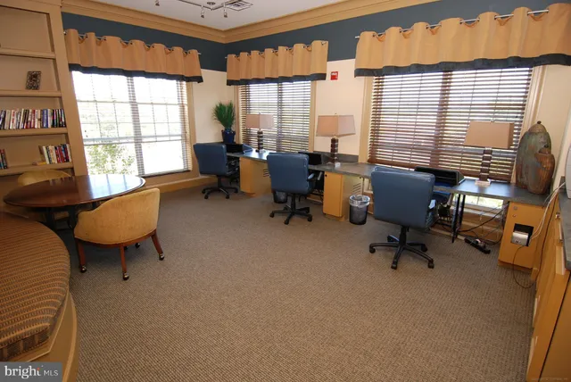a roof deck with table and chairs and potted plants