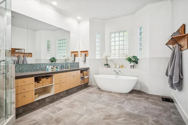 a spacious bathroom with a tub sink and mirror
