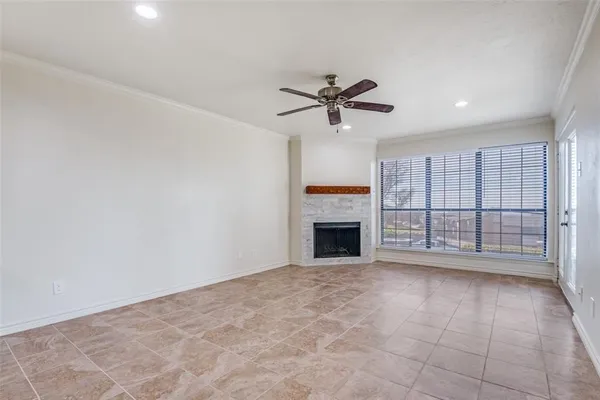a view of an empty room with a fireplace and a window