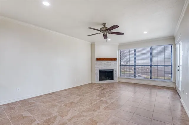 a view of an empty room with a fireplace and a window