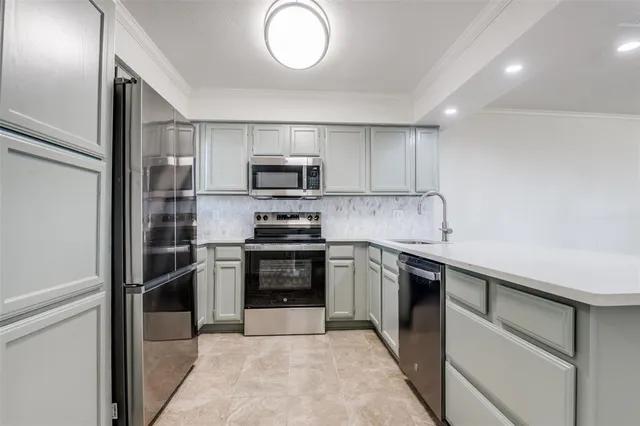 a kitchen with kitchen island granite countertop stainless steel appliances and a sink