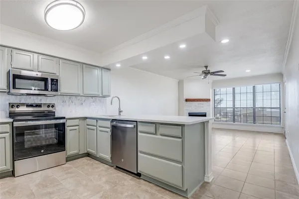 a kitchen with granite countertop a sink stainless steel appliances and cabinets