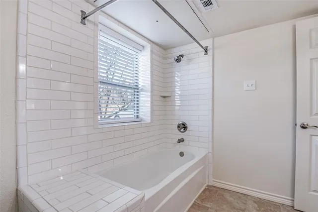 a bathroom with a bathtub and shower