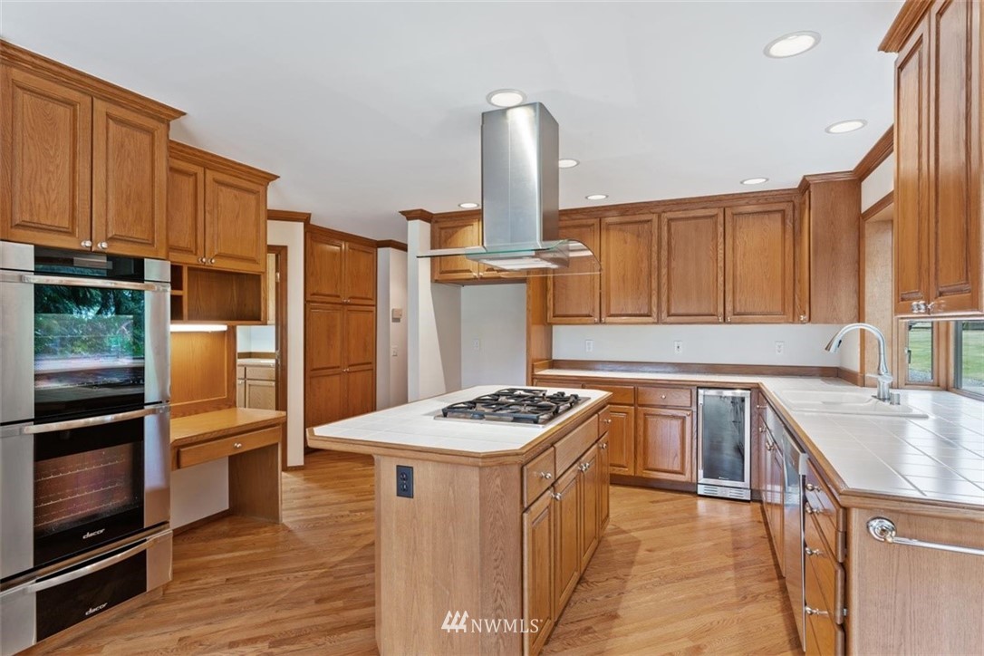 4801 166th Place Southeast Bothell, WA 98012 - Photo 13 of 40 a kitchen with stainless steel appliances granite countertop a sink refrigerator and cabinets